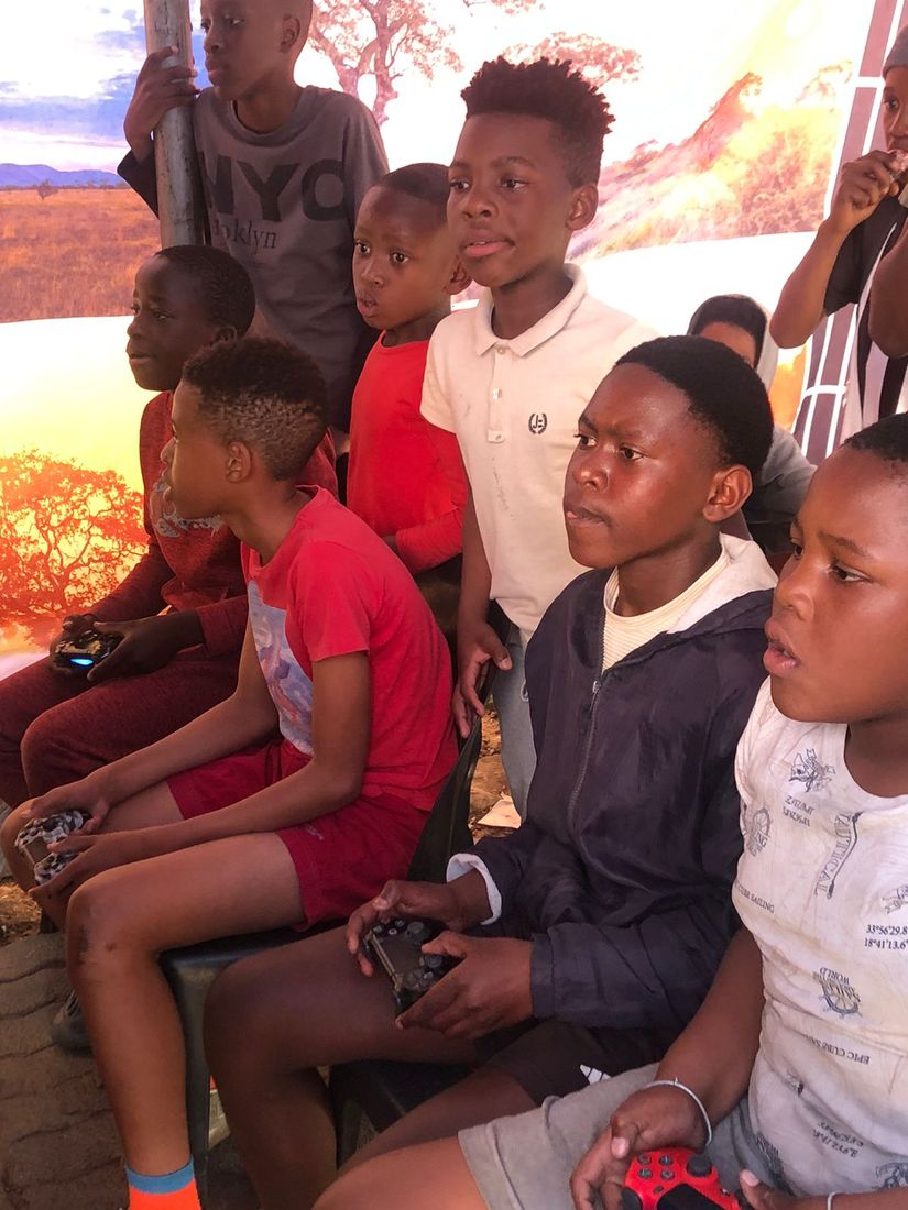 A row of young players gripping controllers, locked in