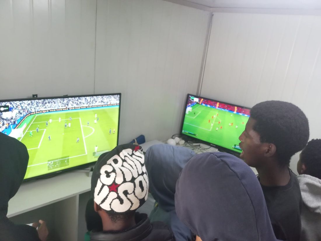 Players shouting at a football match on two screens