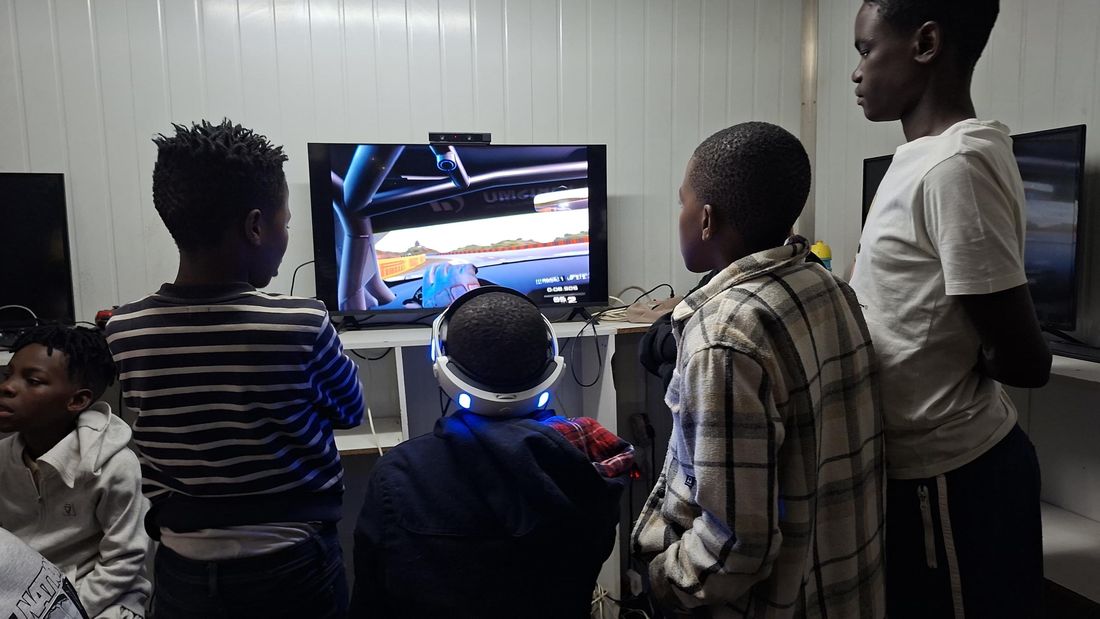 Close-up of a player on the racing wheel wearing a VR headset